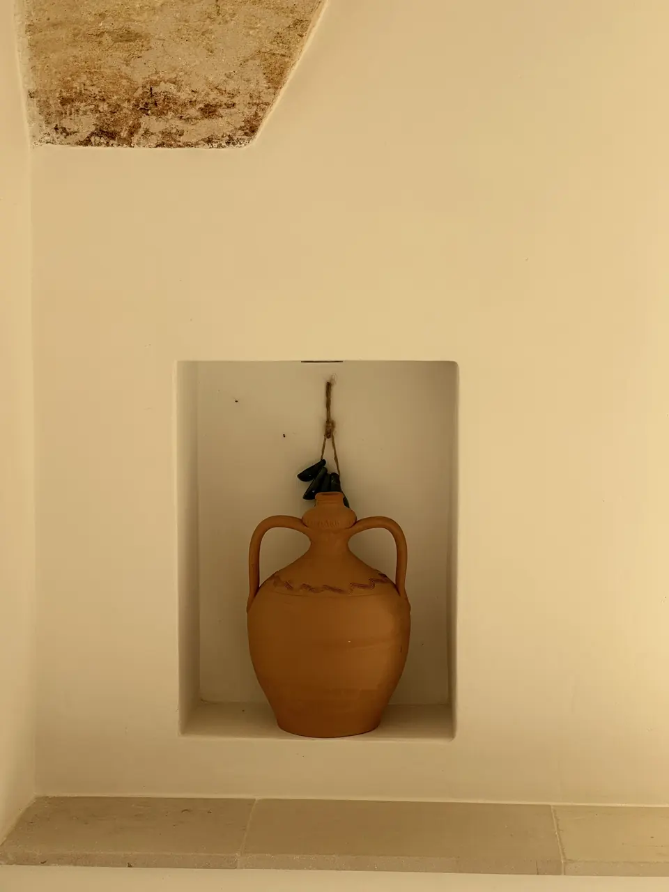 Terracotta amphora in a white niche