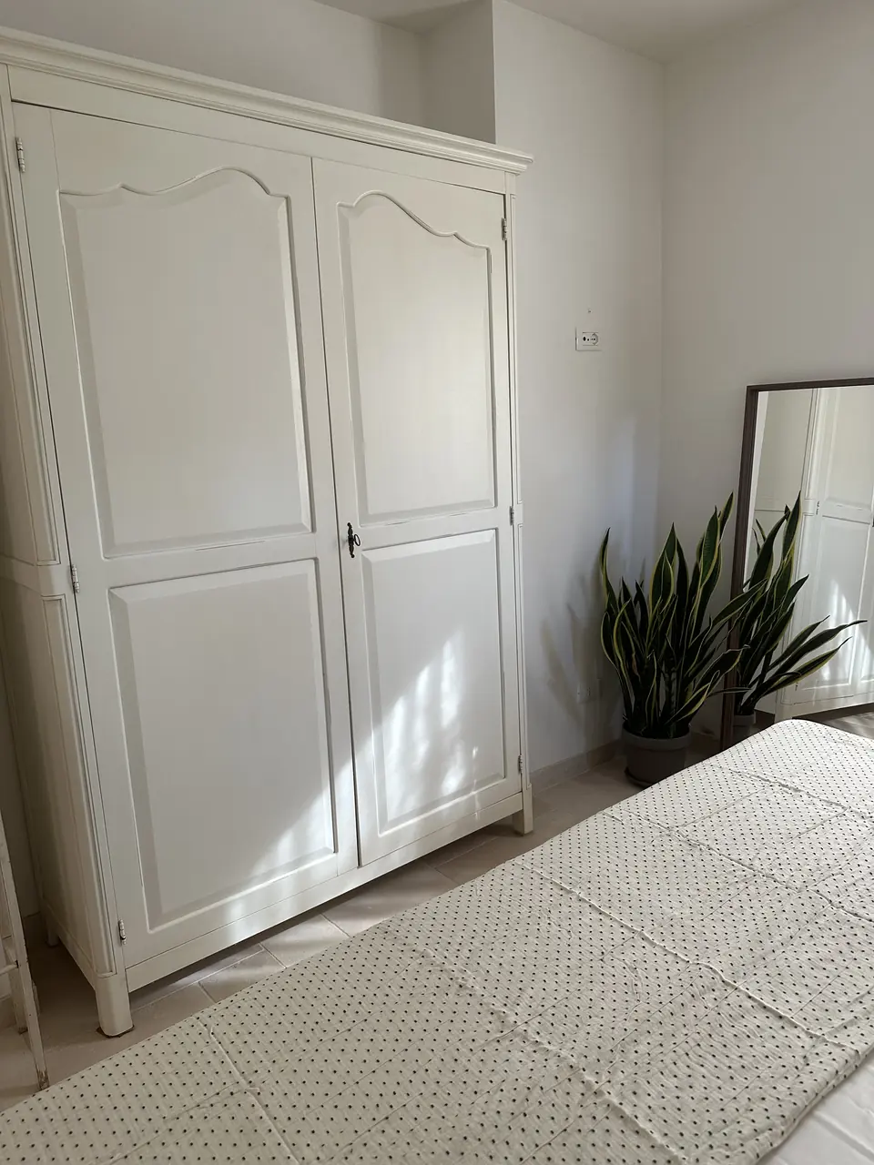 Bedroom with a large white wardrobe